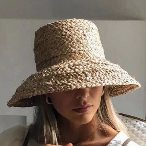 Chapeau de Plage Femme en Raphia sur un mannequin, large bord, parfait pour les journées ensoleillées.