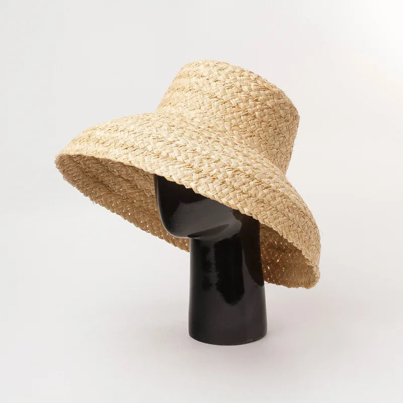 Chapeau de Plage Femme en Raphia sur un mannequin, large bord, parfait pour les journées ensoleillées.