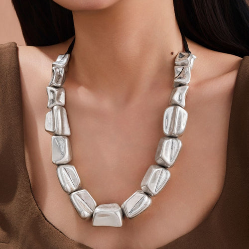 Collier géométrique carré tressé en argent antique, un bijou statement au design exagéré et aux lignes noires contrastantes.
