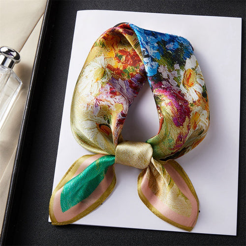 Carré de soie 100 pourcent véritable, foulard polyvalent aux couleurs vibrantes sur un livre.