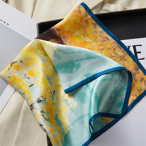 Carré de soie 100 pourcent véritable, foulard polyvalent aux couleurs vibrantes sur un livre.
