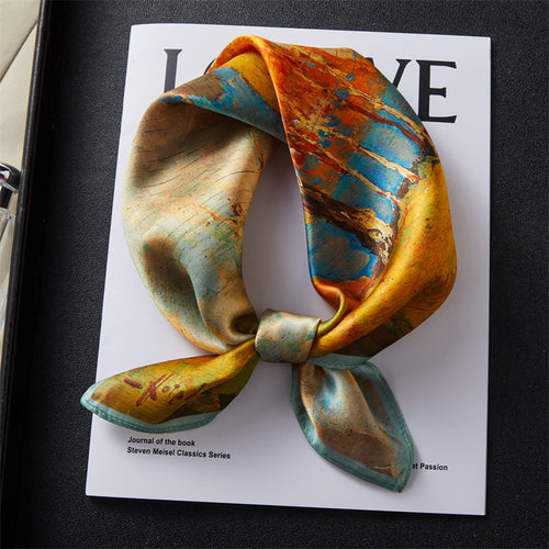 Carré de soie 100 pourcent véritable, foulard polyvalent aux couleurs vibrantes sur un livre.