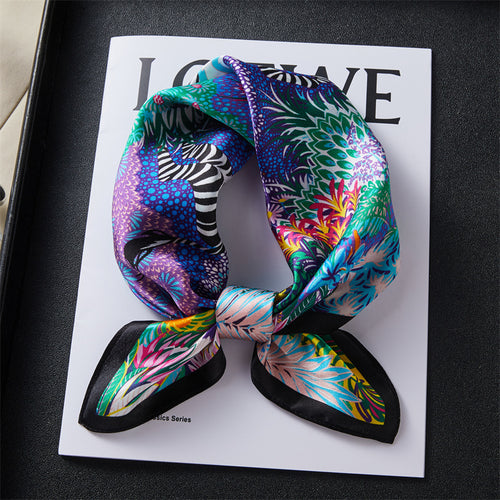 Carré de soie 100 pourcent véritable, foulard polyvalent aux couleurs vibrantes sur un livre.