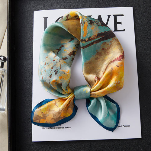 Carré de soie 100 pourcent véritable, foulard polyvalent aux couleurs vibrantes sur un livre.