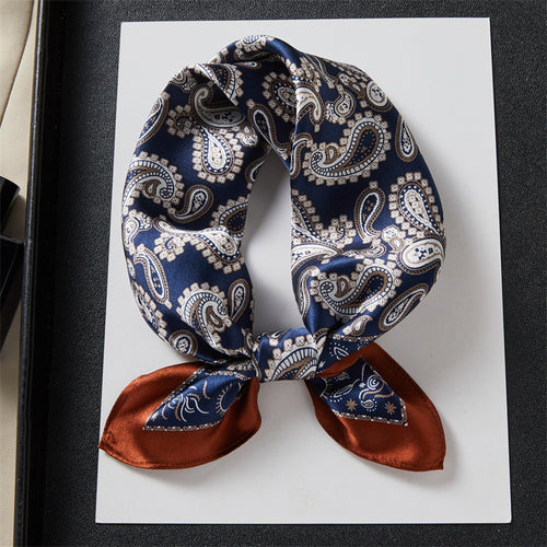 Carré de soie 100 pourcent véritable, foulard polyvalent aux couleurs vibrantes sur un livre.