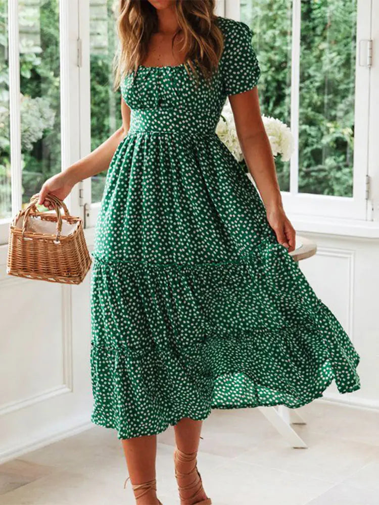 Robe vintage imprimée femme avec manches bouffantes, col carré, style plage, motif floral vert et blanc.