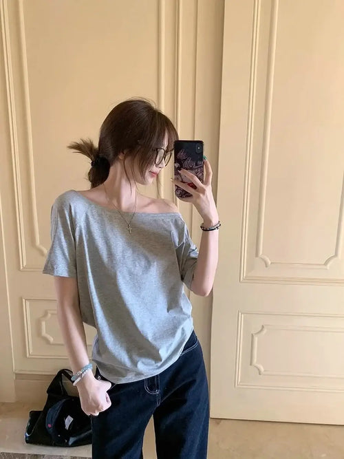 T-shirt femme Y2K Streetwear en gris, style décontracté avec manches courtes, porté sur l'épaule.
