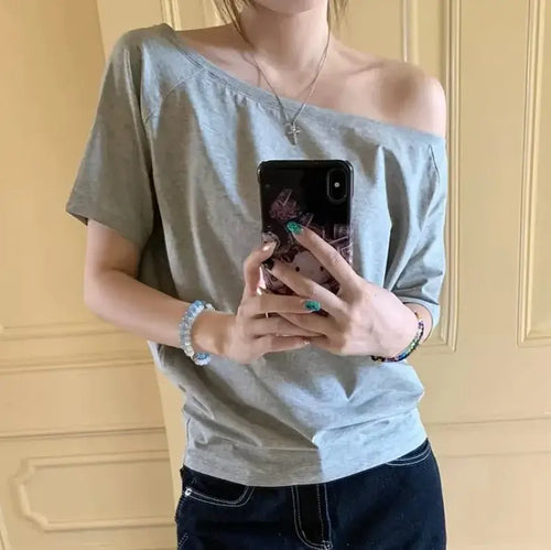 T-shirt femme Y2K Streetwear en gris, style décontracté avec manches courtes, porté sur l'épaule.