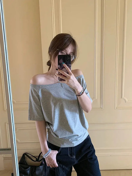 T-shirt femme Y2K Streetwear en gris, style décontracté avec manches courtes, porté sur l'épaule.