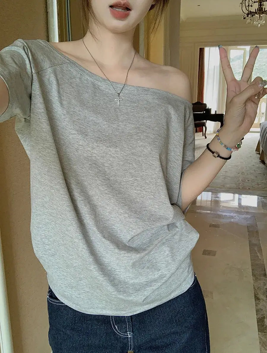 T-shirt femme Y2K Streetwear en gris, style décontracté avec manches courtes, porté sur l'épaule.