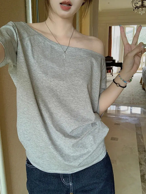T-shirt femme Y2K Streetwear en gris, style décontracté avec manches courtes, porté sur l'épaule.