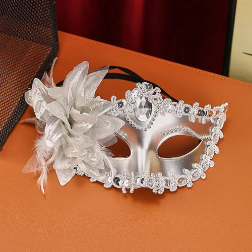 Masque de mascarade fleurs & strass porté par une femme avec des décorations florales et strass, parfait pour une soirée.