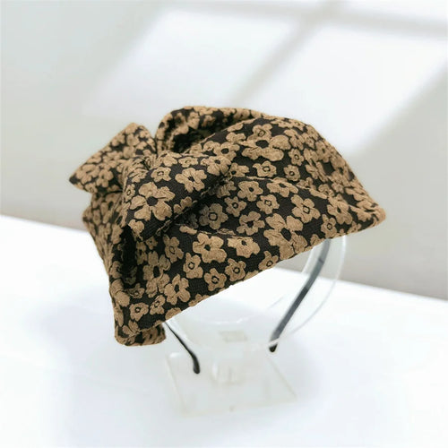 Chapeau Haut de Forme Femme en tissu marron avec fleurs, accessoire élégant pour une tenue rétro.