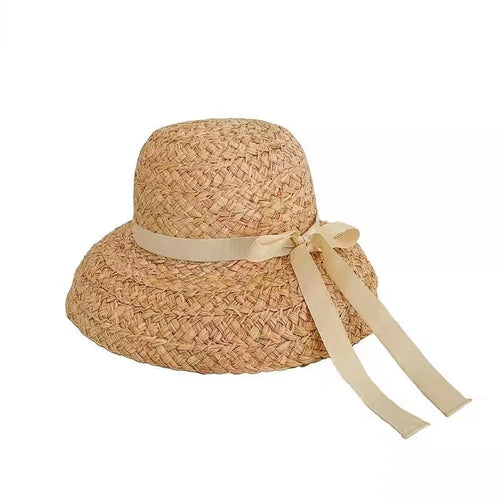 Chapeau de Plage Femme en Raphia sur un mannequin, large bord, parfait pour les journées ensoleillées.